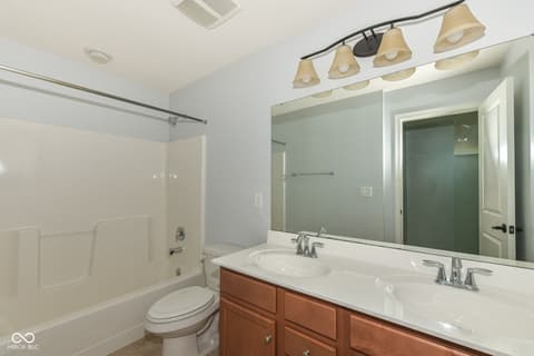 Bedroom at 11946 Eaglerun Way, Zionsville, IN — Bright bedroom with ceiling fan and neutral finishes