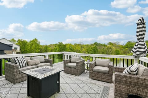 Outdoor living area at 18757 Dooney Court, Noblesville, IN — Expansive composite deck with panoramic wooded views.