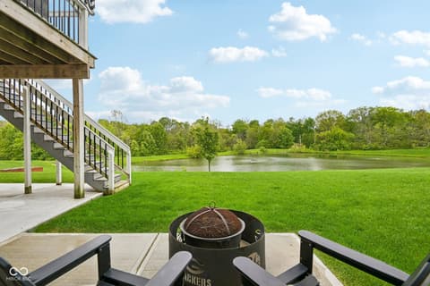 Backyard at 18757 Dooney Court, Noblesville, IN — Stunning lakefront property with elevated deck and fire pit.