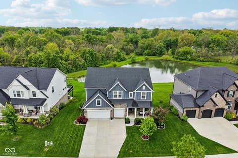 Aerial view at 18757 Dooney Court, Noblesville, IN — Stunning waterfront home with mature trees and pond views.
