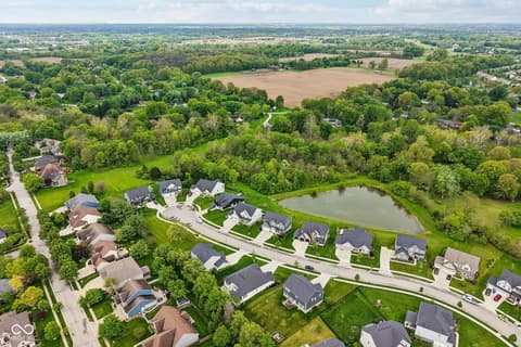 Aerial view at 18757 Dooney Court, Noblesville, IN — Exclusive gated community with pond and mature landscaping.