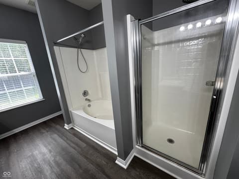 Primary bathroom at 13563 Guy Street, Fishers, IN — Modern spa-like primary bath with dual shower and tub.